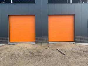 2 oranje bedrijfsdeuren gemonteerd door Ton Smit deuren