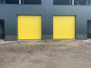 2 gele bedrijfsdeuren gemonteerd door Ton Smit deuren