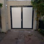 Opneslaande garagedeur uitgevoerd in twee kleuren gemonteerd door Ton Smit Deuren