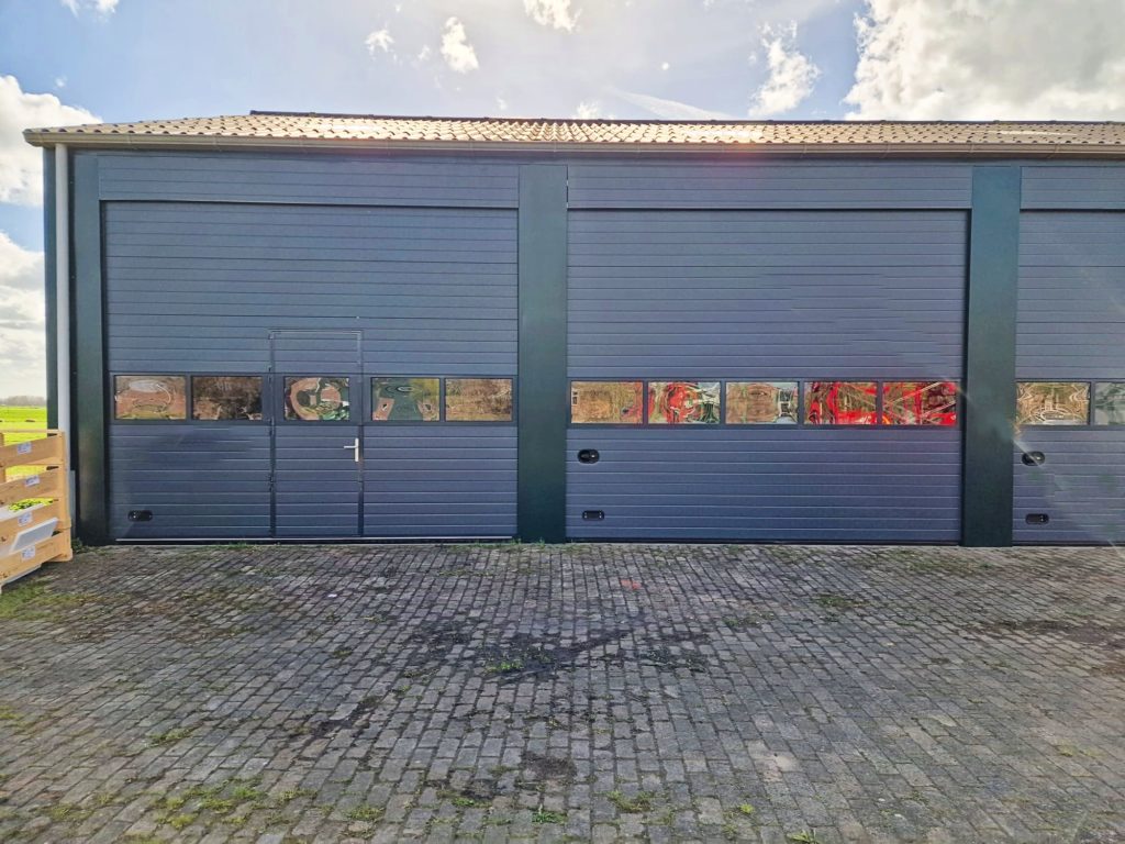Resultaat project in Oudewater, twee overheaddeuren met erboven een vast bovenpaneel gemonteerd door ton smit deuren