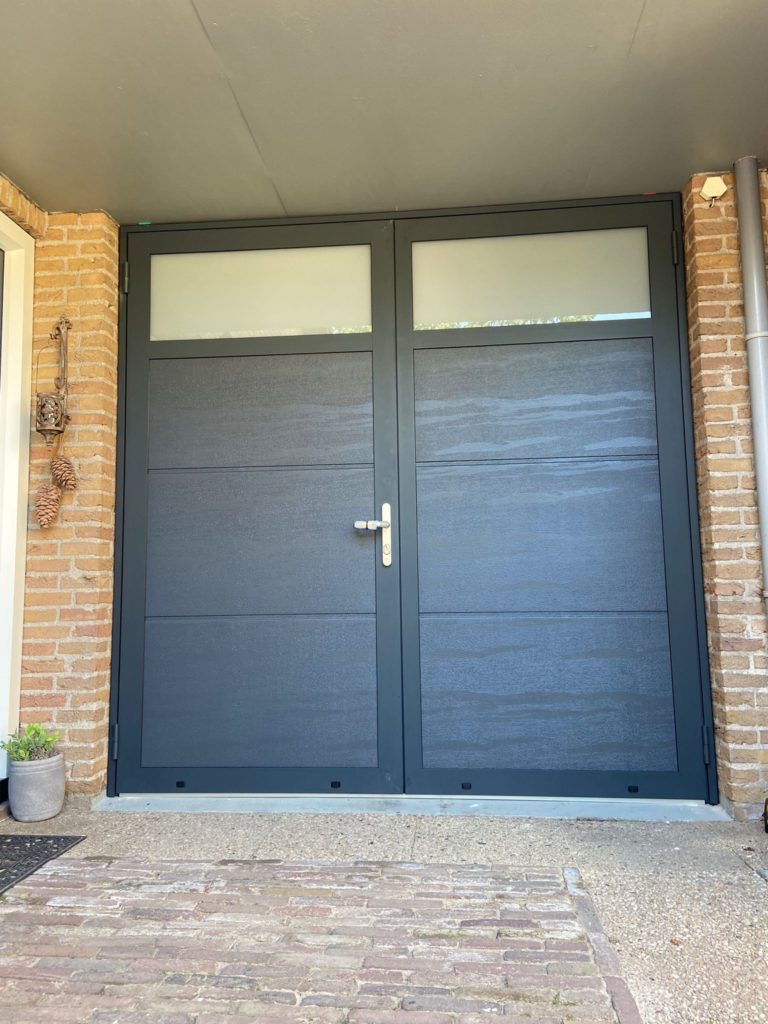 openslaande garagedeur met glas gemonteerd door Ton Smit Deuren