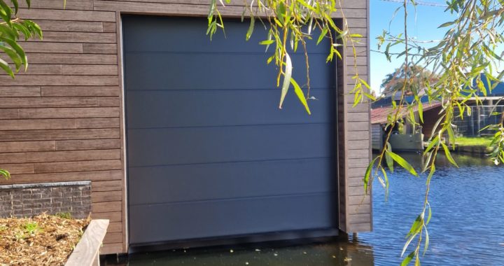 Deze prachtige elektrische garagedeur hebben wij gemonteerd in een boothuis.